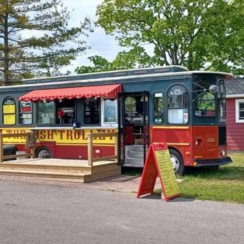The Fish Trolley: a red and green trolley car with a walk-up window, red awning, and menu boards out front