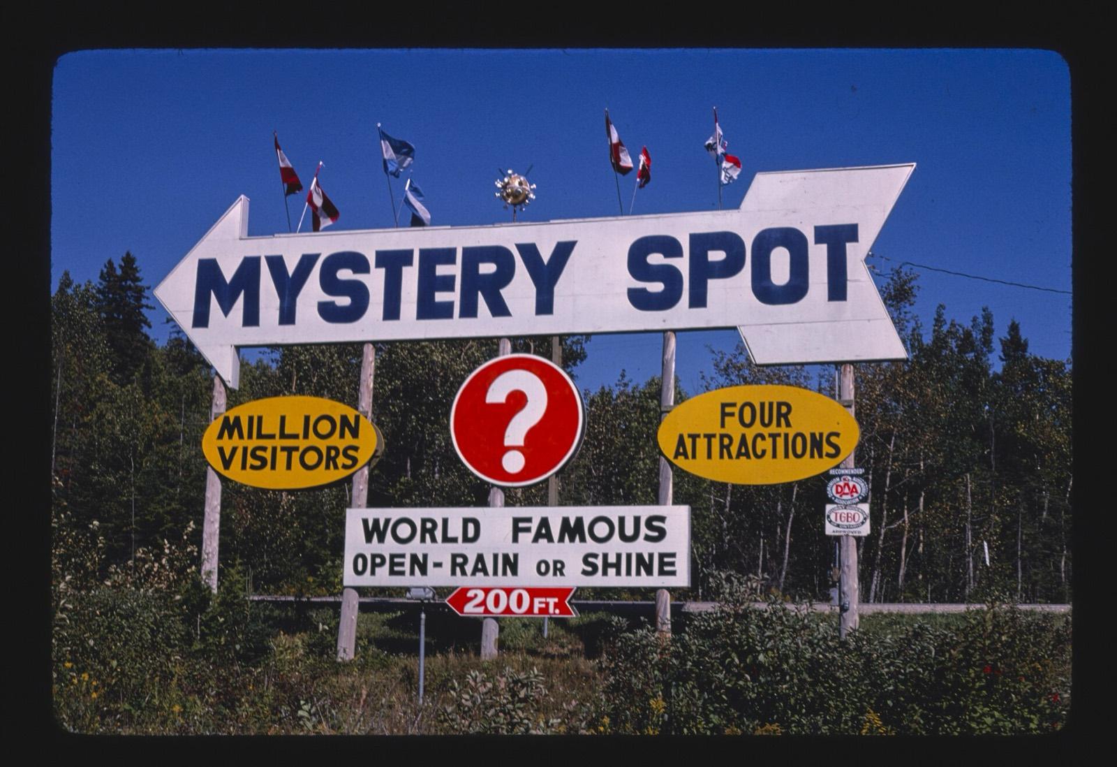 Vintage Mystery Spot roadside arrow sign with flags on top