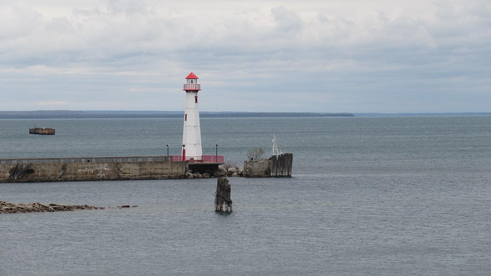 Wawatam Lighthouse, white with a red lantern room, on the pier at St. Ignace